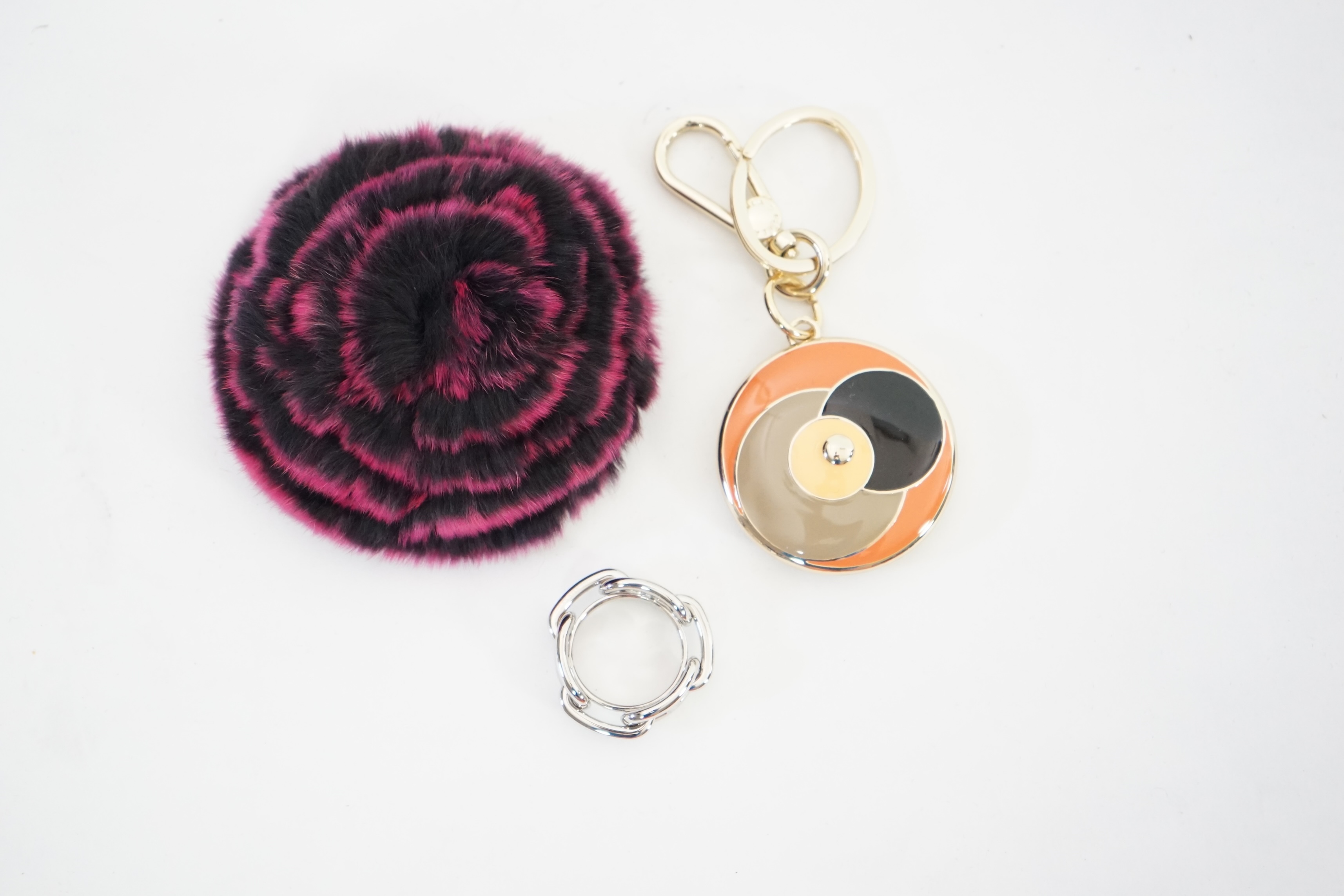 A boxed Hermes scarf ring, with box and bag and a Furla key ring and fur brooch.